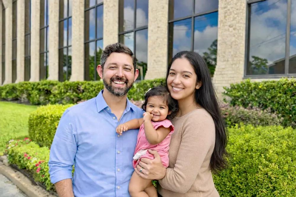 Dr. Richard Sharma and Dr. Diljot Virdi, owners of Mulberry Chiropractic, with their daughter outside the Houston office